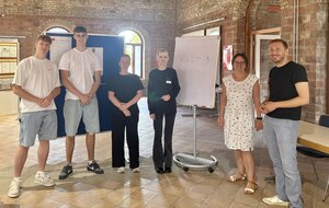 Die Gruppe steht im Ziegeleimusuem vor zwei Flipcharts.